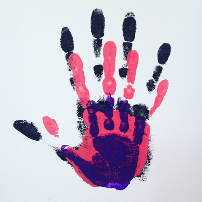 Vater, Mutter, Kind: 3 verschiedenfarbige Handabdrücke übereinander